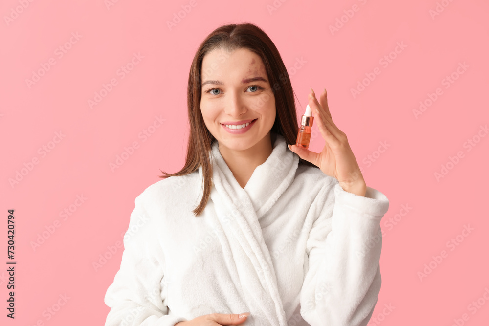 Beautiful woman in bathrobe with serum on pink background Beautiful woman in bathrobe with serum on pink background