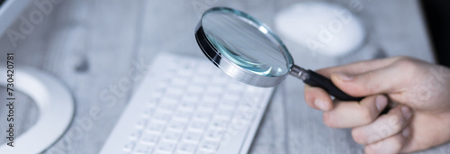 man hand magnifier on keyboard