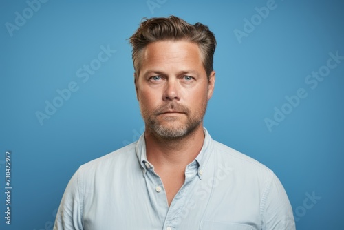 Portrait of a handsome middle-aged man on blue background. © Iigo