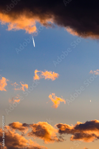 Real sunset sky, colorful sky during sunset or sunrise, weather, colorful colors of the sky. A condensation trail, called cirrus homogenitus, in the sky. Contrail in a beautiful sunset sky photo