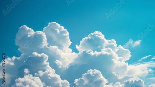 Fluffy white clouds in a bright blue sky background