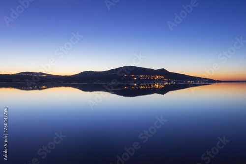 The reflection of the Pálava Mountains on a calm water surface at a wonderful sunset. The calm level of the Novomlýn Reservoir in South Moravia.
