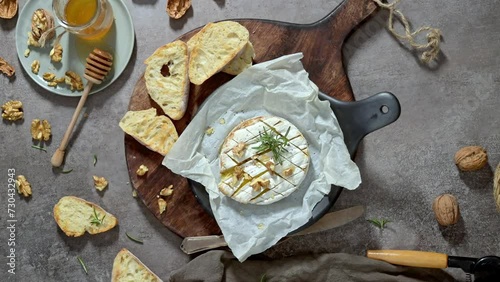 Brie type of cheese. Camembert cheese. Fresh sliced Brie cheese on a wooden tray with nuts, honey and leaves. Italian, French cheese. photo