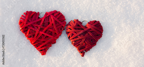 Happy valentines day background with two red hearts on white snow .