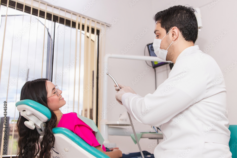 Dentist explaining the work process to his patient in the dental office. Dentist explaining the work process to his patient in the dental office.