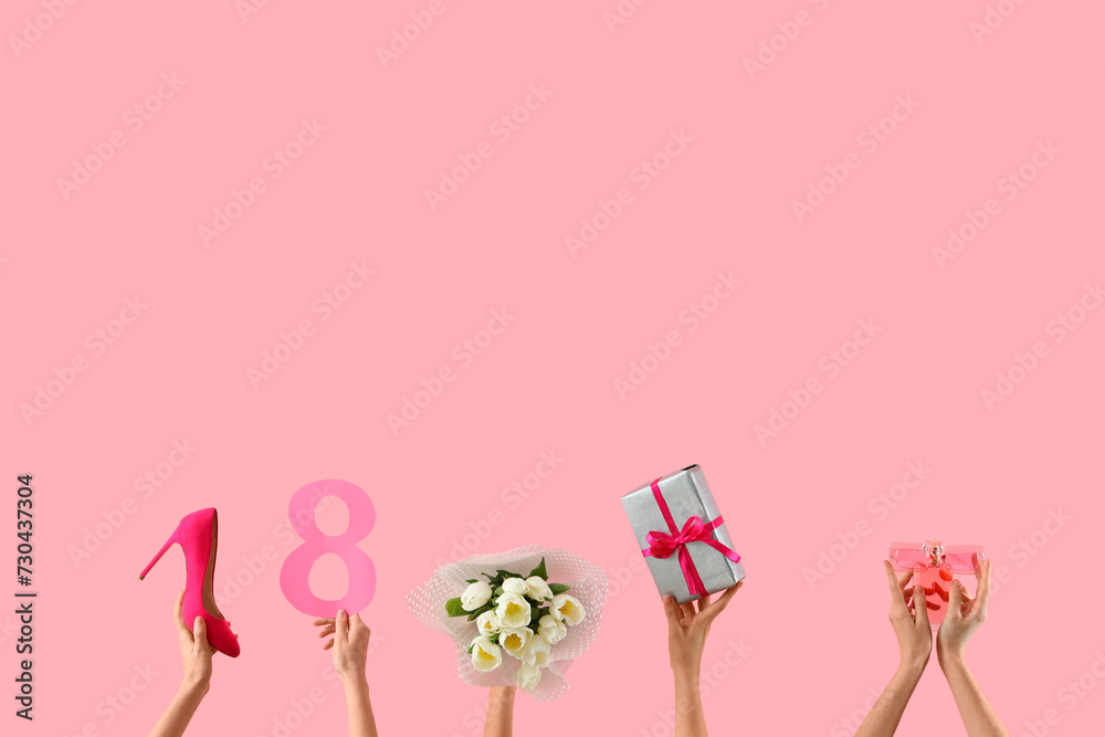 Female hands with bouquet of tulips, high heel shoe and gift box on pink background. International Women's Day celebration