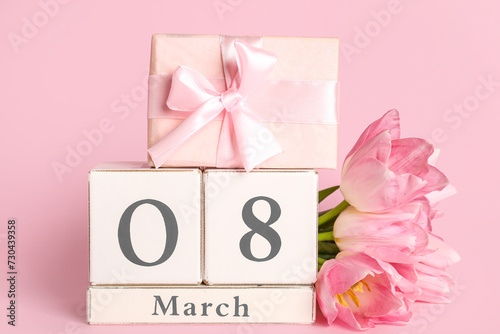 Cube calendar with date 8 MARCH, gift box and beautiful tulips on pink background. International Women's Day