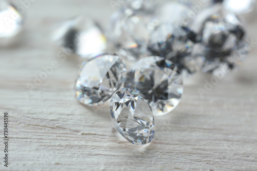 Beautiful shiny diamonds on light wooden table