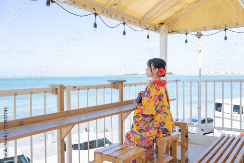 沖縄県豊見城市瀬長のウミカジテラスの海の見える場所で琉装を着た２０代の若い日本人女性 A young Japanese woman in her 20s in Ryukyu dress at a place with a view of the sea on Umikaji Terrace in Senaga, Tomigusuku City, Okinawa Prefecture photo