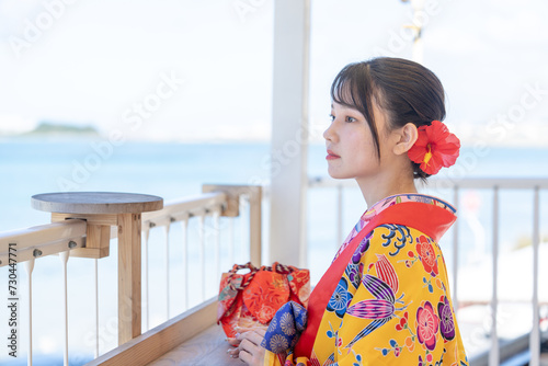 沖縄県豊見城市瀬長のウミカジテラスの海の見える場所で琉装を着た２０代の若い日本人女性 A young Japanese woman in her 20s in Ryukyu dress at a place with a view of the sea on Umikaji Terrace in Senaga, Tomigusuku City, Okinawa Prefecture