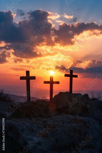 silhouette of three crosses on a rock, sunset on the background, easter concept 