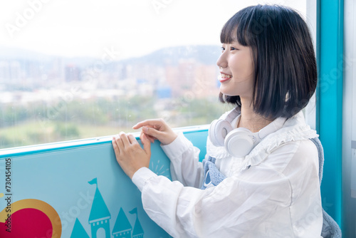 台湾台北市士林区にある遊園地の観覧車で遊ぶ２０代の若い台湾人女性A young Taiwanese woman in her 20s playing on the Ferris wheel of an amusement park in Shilin District, Taipei City, Taiwan photo