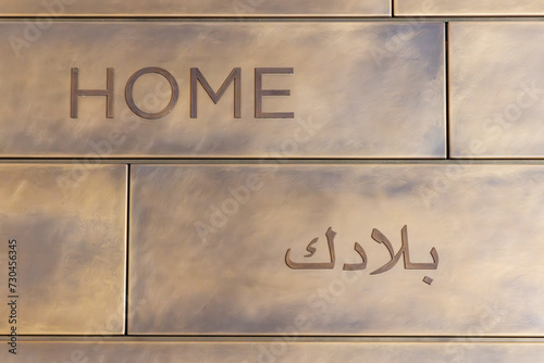 Fototapeta Naklejka Na Ścianę i Meble -  The word home in English and Arabic on a tile wall.