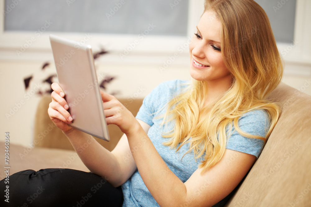 Young Woman Reading a Digital Tablet on Sofa Young Woman Reading a Digital Tablet on Sofa