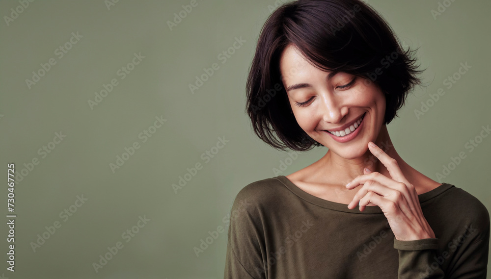 Portrait of a beautiful young asian woman smiling against green background Portrait of a beautiful young asian woman smiling against green background