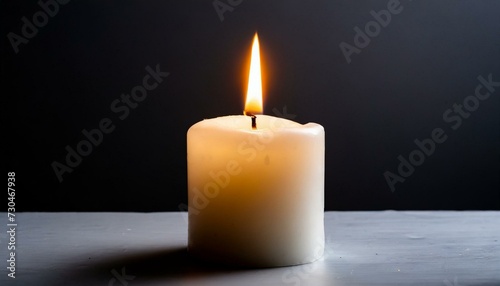 White burning candle on a black background 