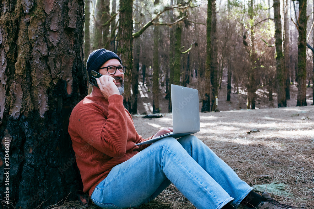One man using technology connection in nature park forest woods. Remote worker small travel business lifestyle people. Working in the nature alternative office. Small business. Travelers job life One man using technology connection in nature park forest woods. Remote worker small travel business lifestyle people. Working in the nature alternative office. Small business. Travelers job life