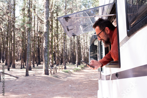 One man enjoying the view outside the window of a motorhome camper van enjoying vanlife and alternative travel vehicle vacation holiday. Freedom. Nomadic lifestyle people fulltimers. Free parking van