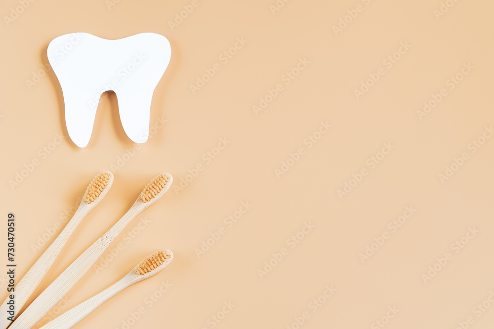 International Dentist Day. Eco-friendly wooden toothbrushes on beige background. Dental care concept.