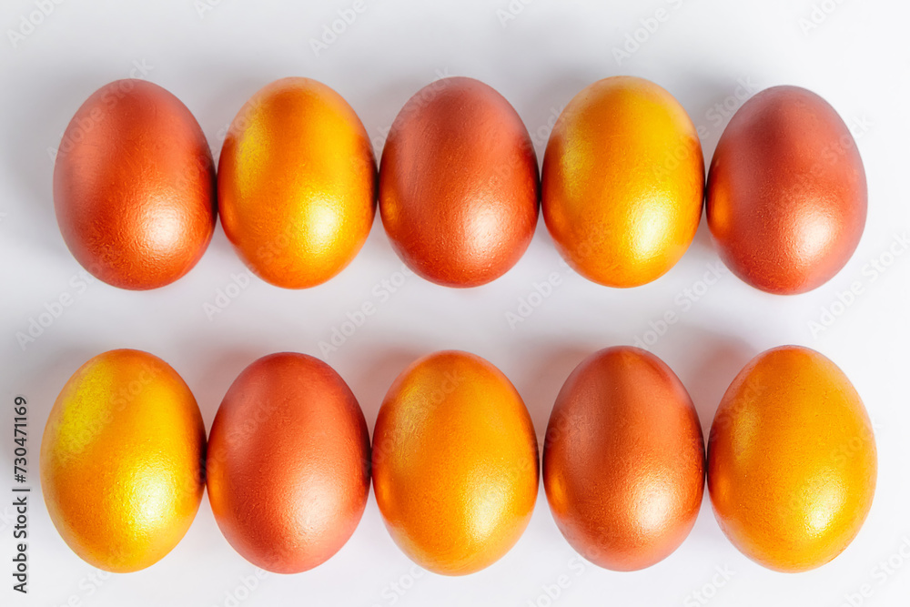 Shiny golden Easter eggs close-up on a white background. Shiny golden Easter eggs close-up on a white background.