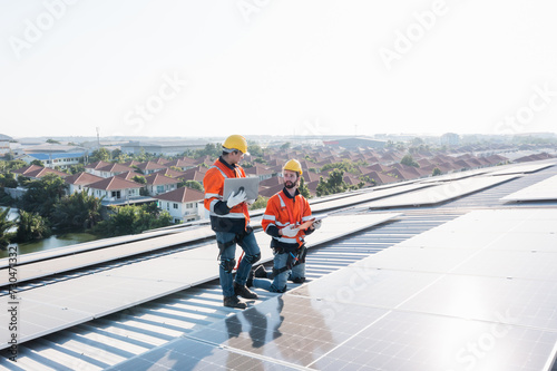 Engineering technician professional trained in skills and techniques installing solar photovoltaic panels system, engineer service check installation solar cell on factory roof, technology solar cell