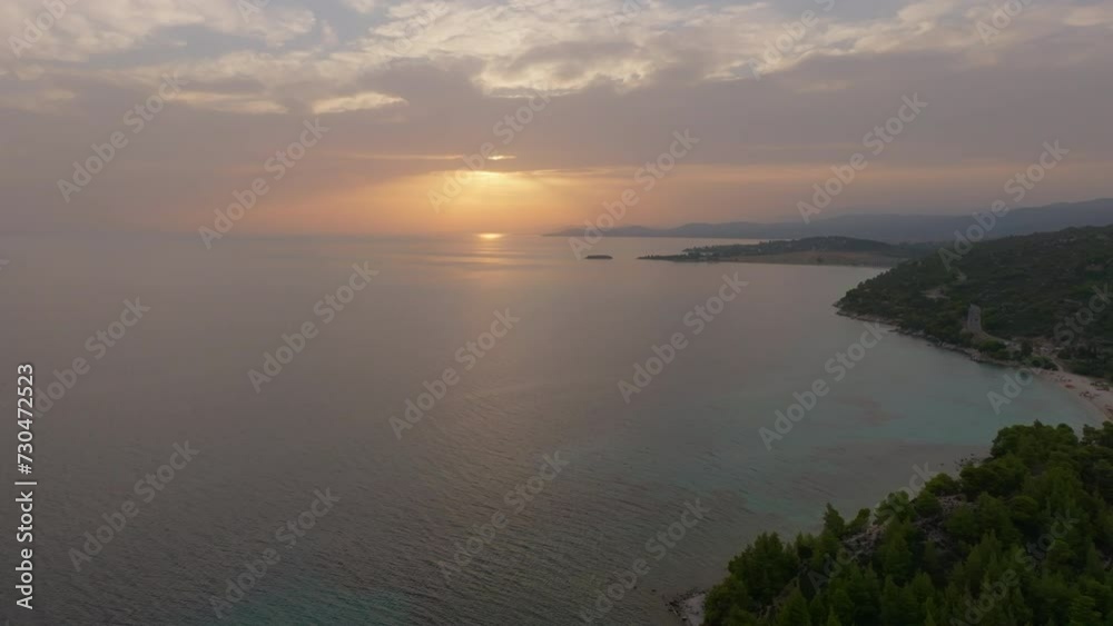 Aerial shot of a drone capturing a cinematic forward flight over a tranquil sea as the sun sets, with golden hues reflecting on the water and silhouetted shoreline Aerial shot of a drone capturing a cinematic forward flight over a tranquil sea as the sun sets, with golden hues reflecting on the water and silhouetted shoreline