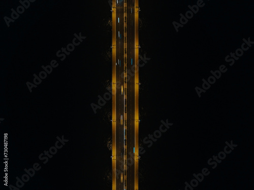 Aerial top view of the bridge in the modern city, drone view of the bridge with illumination. Aerial view traffic at night on bridge over river. © fifthplanet