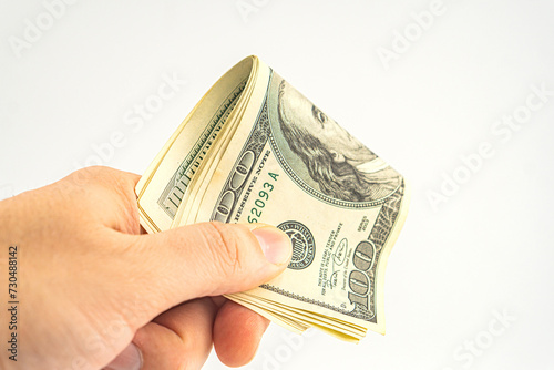 Hand holding money isolated on white background. One hundred Dollars bill on man hand to paying and giving. photo