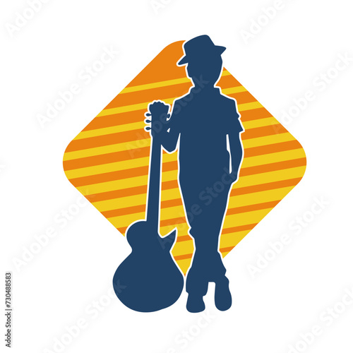 Silhouette of a young kid in pose with an acoustic guitar. Silhouette of a young musician in pose with acoustic guitar musical instrument.