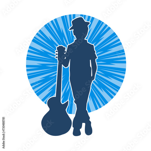 Silhouette of a young kid in pose with an acoustic guitar. Silhouette of a young musician in pose with acoustic guitar musical instrument.
