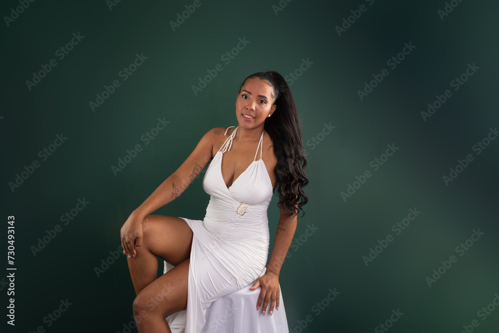 Beautiful brunette woman sitting with hands on her knees posing for photo. Beautiful brunette woman sitting with hands on her knees posing for photo.