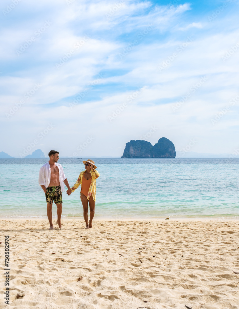 happy young couple Asian woman and European men on the beach of Koh Ngai island in Thailand