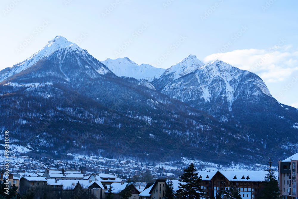 Cityscape of Brianson, ski resort in France. Mountain covered with snow and fog. Alpine landscape in Europe.