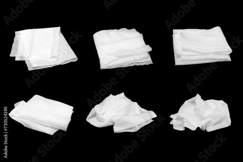 Wet tissues folded in various shapes, black background. photo