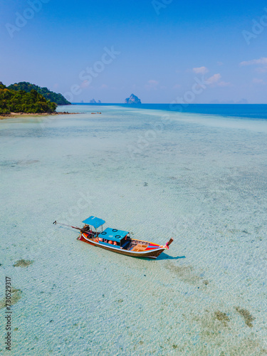 longtail boat in the turqouse colored ocean with clear water at Koh Kradan Thailand