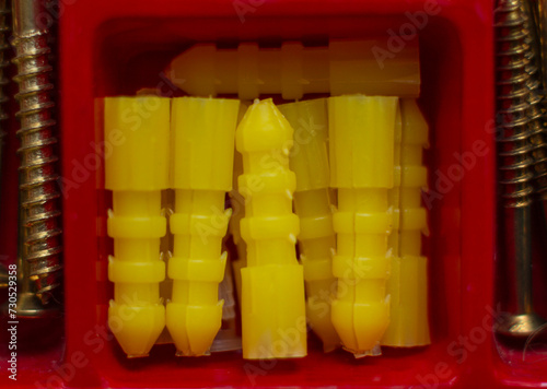 close-up de taquetes de plástico de color amarillo en recipiente rojo