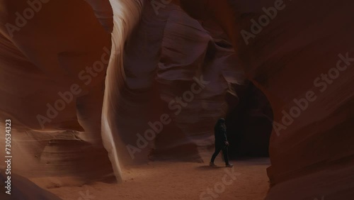 Young woman at Antelope Canyon, Arizona, beautiful smooth wavy sandstone walls.