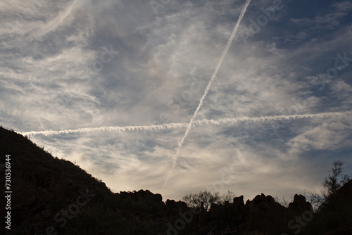 Two aircraft contrails cross in the sky