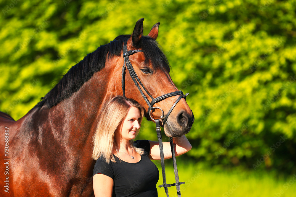 Obraz premium Horse and girl head portraits against a green background in the sunshine