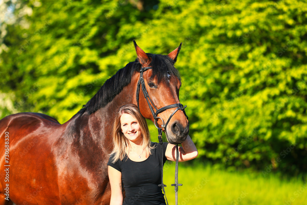 Obraz premium Horse and girl head portraits against a green background in the sunshine