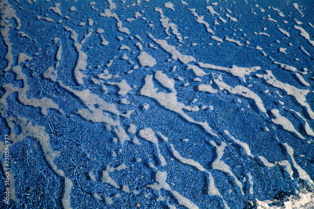 Abstract view with sea waves texture. Foam of sea waves in color abstraction. The structure of the sea surf in shallow water is specially tinted in different colors. View from above. Abstract view with sea waves texture. Foam of sea waves in color abstraction. The structure of the sea surf in shallow water is specially tinted in different colors. View from above.