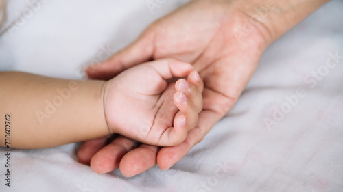 Close up baby hand on mother's hands.