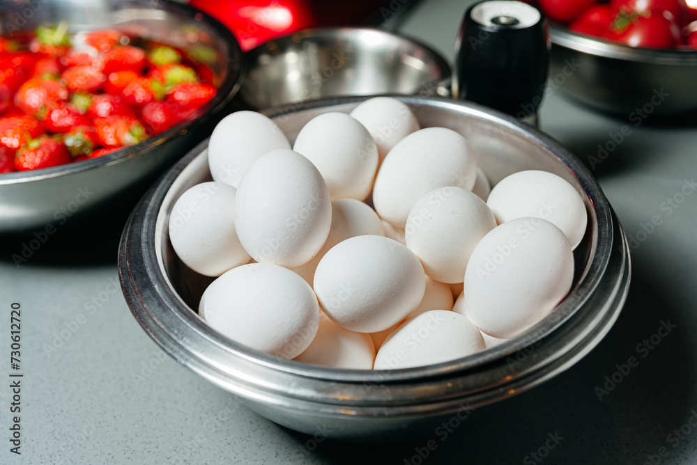 Bowl of Fresh White Eggs Ready for Cooking. A bowl filled with white eggs marked with red stamps, sitting on a kitchen counter, ready for culinary use. Bowl of Fresh White Eggs Ready for Cooking. A bowl filled with white eggs marked with red stamps, sitting on a kitchen counter, ready for culinary use.