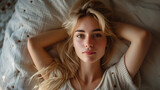 Blonde young woman lying in bed, relaxed, super comfortable,