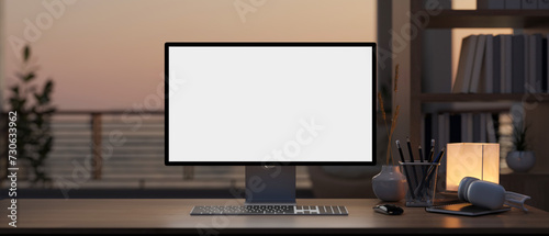 A computer mockup on a hardwood desk in a modern home office with a large window and balcony. © bongkarn