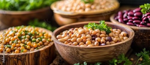 Raw beans in wooden bowls garnished with parsley on a table