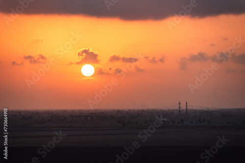 Beautiful, red, sunset sky over the Egyptian coast. View from cargo ship sailing through Suez Canal.