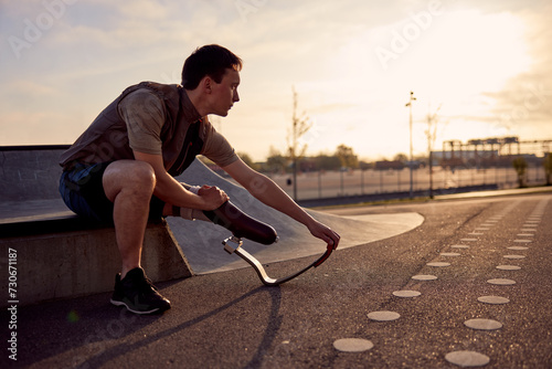 Man with a prosthetic running blade stretching outside photo