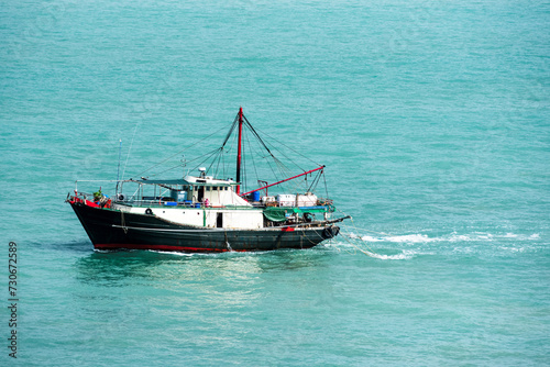 Fishing boat sailing through calm waters near Vietnamese sea coast. © Mariusz