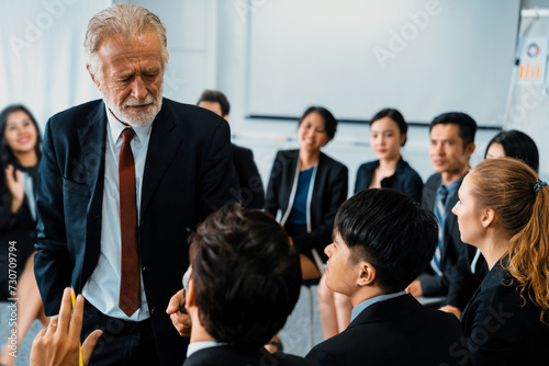 Senior leader speaker speaks to public people audience in training workshop or conference. Mature lecturer is CEO executive manager leading symposium event. International business seminar concept. uds